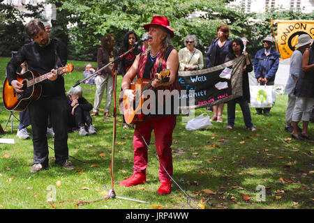 London, UK. 6. August 2017. Peter Dunne (Volkssänger) singen bei der Kampagne für nukleare Abrüstung jährliche Gedenken an die Atombombenabwürfe auf Hiroshima, Japan am Tavistock Square, London, Vereinigtes Königreich.  Am 6. August 1967 war ein Kirschbaum auf dem Platz von Camden Rat in Gedenken an die Opfer der Bombardierung gepflanzt. Seither hat eine jährliche Zeremonie um den Baum zu erinnern, den Angriff statt. Bildnachweis: Michael Preston/Alamy Live-Nachrichten Stockfoto