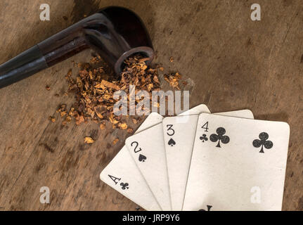 Verbreitung weiße Karten mit schwarzen Symbolen und einer Tabak rauchen Rohr auf einem Holztisch Oberfläche Stockfoto