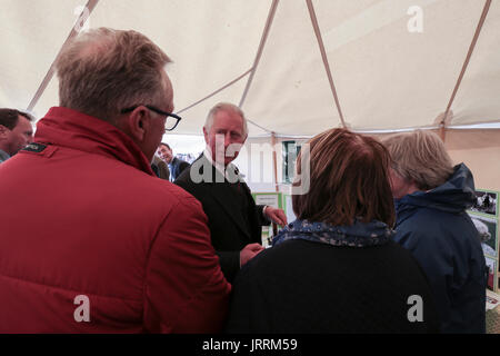 Der Prinz von Wales, bekannt als der Herzog von Rothesay in Schottland, Gespräche mit Vertretern von Mary Ann Cottage vertraut während des Besuchs der Mey-Highland-Games in John O'Groats, Caithness. Stockfoto