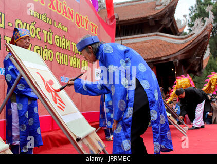 HAI DUONG, VIETNAM, Februar, 15.: der Lehrer in traditionellen Kostümen Buchstaben in das neue Jahr zu schreiben für gutes Glück an Chu Van ein Festival im Februar Stockfoto