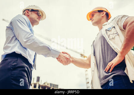 Architekt Ingenieur Händeschütteln andererseits an der Baustelle. Business Teamarbeit, Zusammenarbeit, Erfolg Zusammenarbeit Konzept Stockfoto