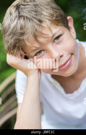 Porträt der Glückliche Junge sitzt im Freien Stockfoto