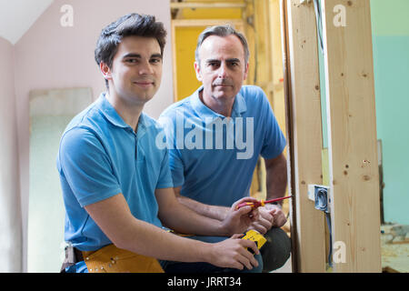 Portrait von Elektriker mit Lehrling Arbeiten im neuen Haus Stockfoto