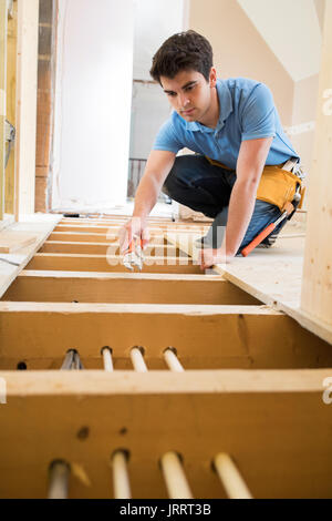 Lehrling Klempner Einbau einer Zentralheizung im Haus Stockfoto