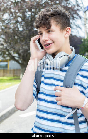 Männliche Jugend Schüler außerhalb der Hochschule Gebäude Gespräch am Handy Stockfoto