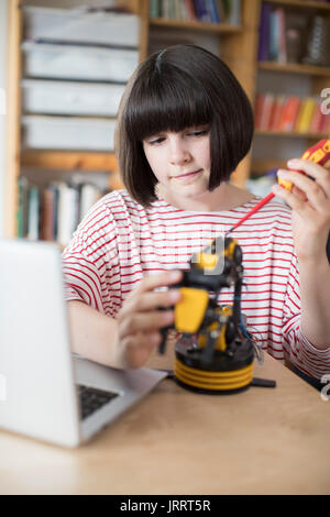 Jugendmädchen Gebäude Roboterarm in der Schule Stockfoto