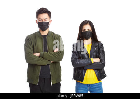 Jungen asiatischen Mann und Frau tragen schwarze Maske auf Kamera runzelte die Stirn, auf weißem Hintergrund. Stockfoto