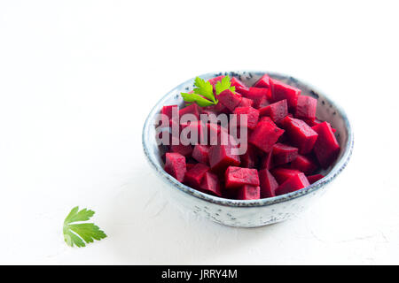 Rote Bete (Zuckerrüben) für Salat in der Schüssel über weißen Hintergrund mit Kopie Raum gehackt. Gesund Zutat. Rohstoffe Zuckerrüben. Stockfoto