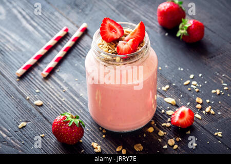 Strawberry Smoothie mit hausgemachtem Müsli. Gesundes Frühstück oder einen Snack. Banane und Erdbeere Smoothie in Glas. Stockfoto