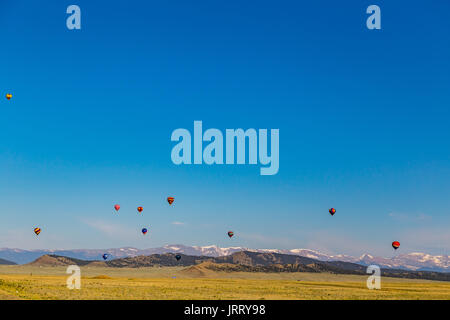 Mit dem Colorado Rocky Mountains als Hintergrund, Heißluftballons profitieren Sie von einer klaren am frühen Morgen und einen offenen ländlichen Bereich zu Verfahren, die o Stockfoto