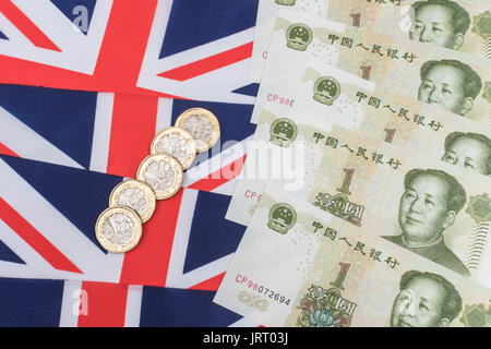 Renminbi Yuan/Rechnungen/Banknoten und neue UK £ 1 Münzen auf einen Union Jack - Metapher für UK-China Handelsbilanz und Exporte - Importe, Yuan Schwäche. Stockfoto