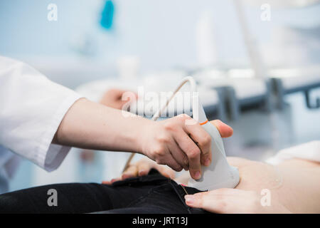 Schwangere Frau, die Ultraschallbehandlung im Krankenhaus. Stockfoto