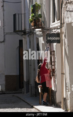 Verkäufer stellen Artikel in der Vorderseite der traditionellen Shop in Ubeda, Andalusien, Spanien Stockfoto