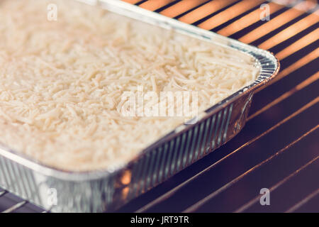 Fertig gebacken Lasagne Bolognese im verfügbaren Folie Teller werden Stockfoto