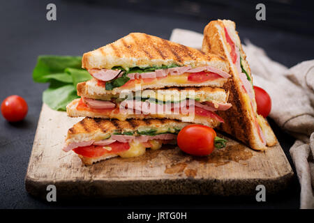 Club Sandwich Panini mit Schinken, Tomaten, Käse und Basilikum. Stockfoto