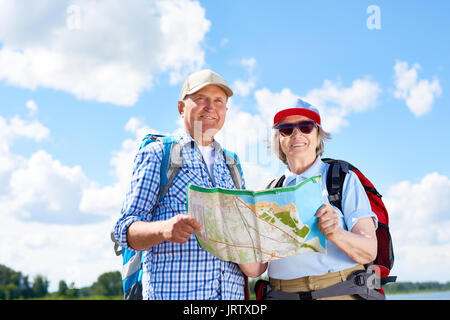 Gerne ältere Touristen Posieren mit Karte Stockfoto