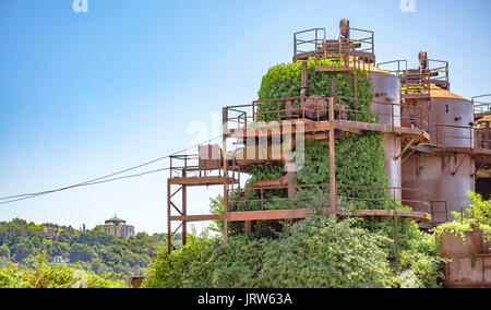 Aufgegeben Maschinen und Speichereinheiten in einem Gas Industrie Gaswerk park Seattle mit Kathedrale im Hintergrund. Maschinen und Speichereinheiten in einem Gas Stockfoto