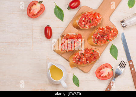 Vorbereitung köstliche italienische Tomaten Bruschetta mit gehacktem Gemüse, Kräutern und Öl Stockfoto