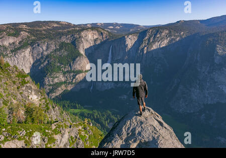 Blick vom Glacier Point von Yosemite Falls. Auf einer Klippe und unten im Tal bei Sonnenaufgang Stockfoto