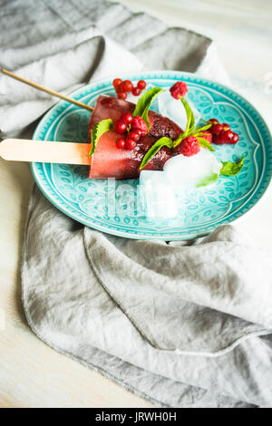 Sommer Obst Dessert - Erdbeer Lutscher mit Minze und Eis auf rustikale Platte auf konkreten Hintergrund Stockfoto