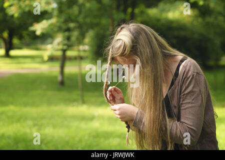 Jugendlich Mädchen an Daisy Blumen im Haar im Green Park von hinten im Sommer Tag Stockfoto