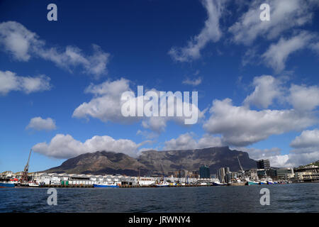 Ein Blick auf die V&A Waterfront und werft mit Wolken über dem Tafelberg, Devil's Peak im Hintergrund in Kapstadt, Western Cape, Südafrika. Stockfoto