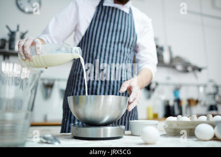 Hinzufügen von Milch Stockfoto