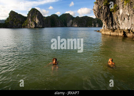 Menschen swmming in abgeschiedenen Strand in isolierten Insel in Ha Long Bay, Vietnam. ruhigen tropischen Strand, Cat ba Nationalpark, Ha Long, Halong Bay, Vietnam Stockfoto