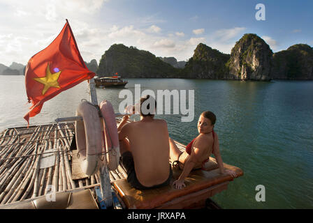 Romantisches Paar in einer chinesischen Dschunke, Halong Bay Tourist Boat tour, Vietnam. Junk, Boot segeln unter karst Kalkstein Berge auf Cat Ba National p Stockfoto