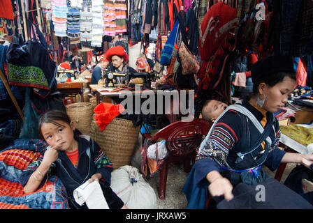 Schwarze Hmong Frauen machen und verkaufen tribal Kunsthandwerk und Kleidung iniside in Sapa, Lao Cai Provinz, Vietnam Stockfoto
