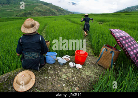 Einige Hmong Frauen essen Neben einem Reisfeld in Sapa Weg in die Dörfer in der Nähe von Lao Chai und ta Van. Vietnam. Stockfoto