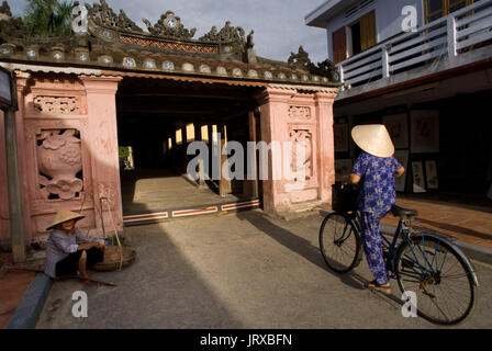 Alte Frau an einem Fahrrad überqueren die japanische bedeckt Brücke in Hoi an ein, UNESCO World Heritage Site, Vietnam, Indochina, Südost-Asien, Asien Stockfoto