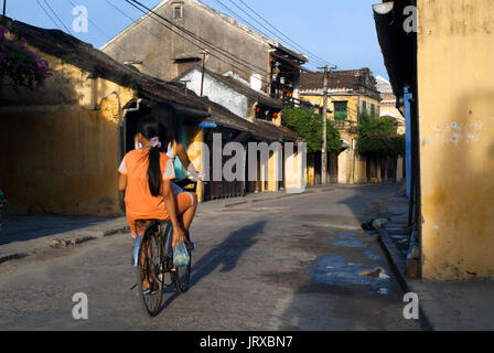 Vietnam, Quang Nam Provinz, Hoi An, die Altstadt, die als Weltkulturerbe von der unesco, traditionellen Haus aufgeführt. Bach Dang Street. Vietnam. Ein Mädchen auf dem Fahrrad. Stockfoto