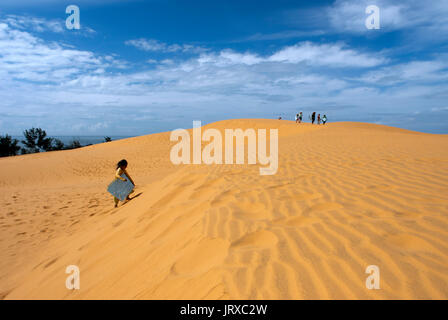 Junge Menschen haben sich funthrowing durch die Wüste Sand an den weißen Sanddünen, Mui Ne, Vietnam. Stockfoto