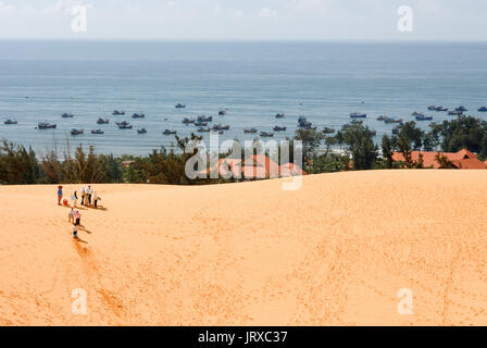 Junge Menschen haben sich funthrowing durch die Wüste Sand an den weißen Sanddünen, Mui Ne, Vietnam. Stockfoto