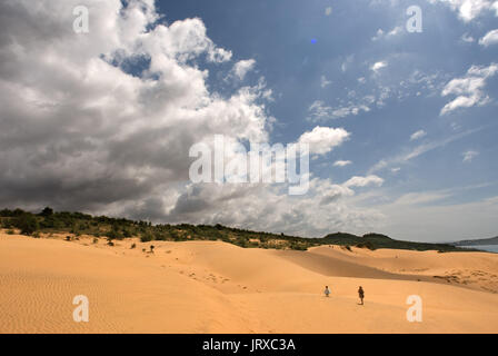 Junge Menschen haben sich funthrowing durch die Wüste Sand an den weißen Sanddünen, Mui Ne, Vietnam. Stockfoto