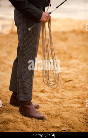 Cowboy während ein Reitzentrum Meisterschaft teilnehmen hält Seil und Peitsche in Andalusien, Spanien Stockfoto