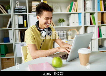 Gerne asiatische Student mit Laptop Stockfoto