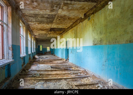 Die zerstörten langen Korridor der verlassenen Schule nach der Tschernobyl-Katastrophe In Evakuierungszone. Folgen der nuklearen Verschmutzung zwanzig Jahre später. Stockfoto