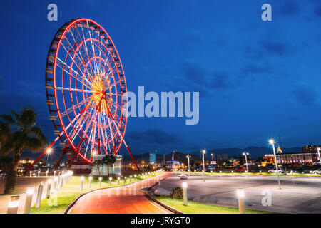 Batumi, Adscharien, Georgia. Riesenrad auf der Promenade in Wunder Park, Amusement Park auf blauen Himmel Hintergrund. Blaue Stunde am Abend oder in der Nacht Stockfoto
