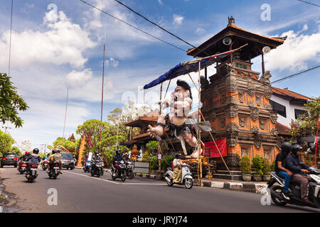 Traditionelle balinesische guardian Statue am Eingang Bali Tempel mit Landschaft verschwommen Straße Hintergrund reisen Touristen auf der Suche nach Abenteuer auf Tropic Stockfoto