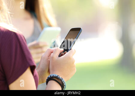 Hände von zwei jugendlich Mädchen mit Smart Phones in der Straße Stockfoto