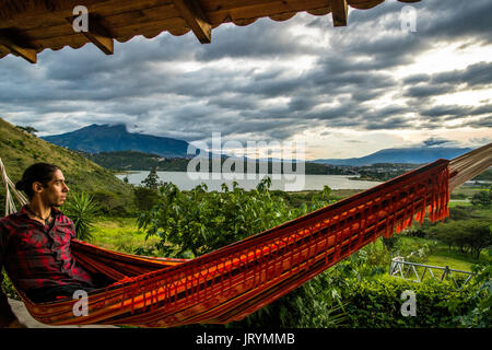 Eine junge Reisende genießen den Sonnenuntergang mit Blick auf die Laguna de Yahuarcocha und Imbabura in Ibarra, Ecuador. Stockfoto