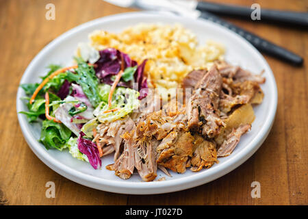 Zog Schweinefleisch mit Kartoffelpüree und gemischten Blätter Salat auf weiße Platte Stockfoto