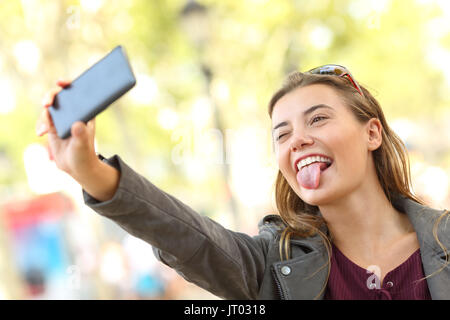 Porträt eines lustigen Jugendlich unter selfies und Grimassen auf der Straße Stockfoto