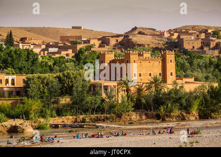 Frauen und Kinder Wäsche Waschen im Fluss, Kalaat M'Gouna, Tal der Rosen. Marokko, Maghreb Nordafrika Stockfoto