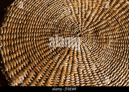 Eine abstrakte Close up Hintergrund einer Hand gewebt, Spirale, texturierte Wicker grass Mat. Stockfoto