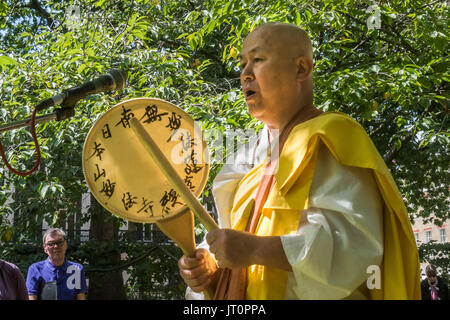 London, UK. 6. August 2017. London, UK. 6. August 2017. Buddhistischer Mönch aus dem Kloster Battersea und Frieden Pagode Reverend Gyoro Nagase rezitiert ein Gebet an der London CND-Zeremonie im Gedenken an die Opfer der Vergangenheit und Gegenwart zum 72. Jahrestag vom Abwurf der Atomic bomb auf Hiroshima und die zweite Atombombe über Nagasaki abgeworfen, drei Tage später. Nach einer Reihe von Vorträgen und Aufführungen gab es eine Schweigeminute, in der der stellvertretende Bürgermeister von Camden und andere Blumen rund um die Festschrift Kirschbaum verlegt. Peter Marshall ImagesLive (Kredit-Bild: © Peter Marshall/Im Stockfoto