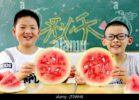 6. August 2017 - Anshan, Anshan, China - Anshan, 6. CHINA-August 2017: (nur zur redaktionellen Verwendung. CHINA aus) Kinder Wassermelonen in Ma'anshan, der ostchinesischen Provinz Anhui, 6. August 2017, Kennzeichnung des solar Begriffs des starten des Herbstes zu genießen. It¡¯s eine chinesische Tradition zu beißen und Früchte am Tag der Start des Herbstes zu genießen. Die traditionellen chinesische Mondkalender teilt das Jahr in 24 solar Begriffe. Beginn des Herbstes, die 13. solar Laufzeit des Jahres, beginnt dieses Jahr am 7. August und endet am 22. Aug. Beginn des Herbstes spiegelt das Ende des Sommers und den Beginn des Herbstes. Die fruchtbare Saison ist approa Stockfoto