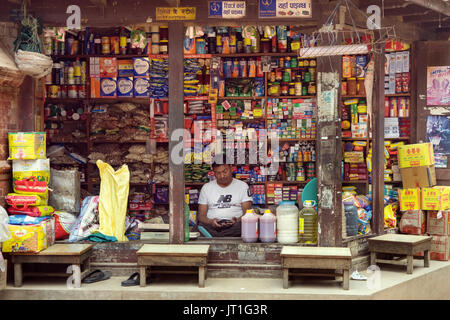 Lebensmittelgeschäft Anbieter, auf sein Handy zu schielen. Bhaktapur, Nepal. Stockfoto